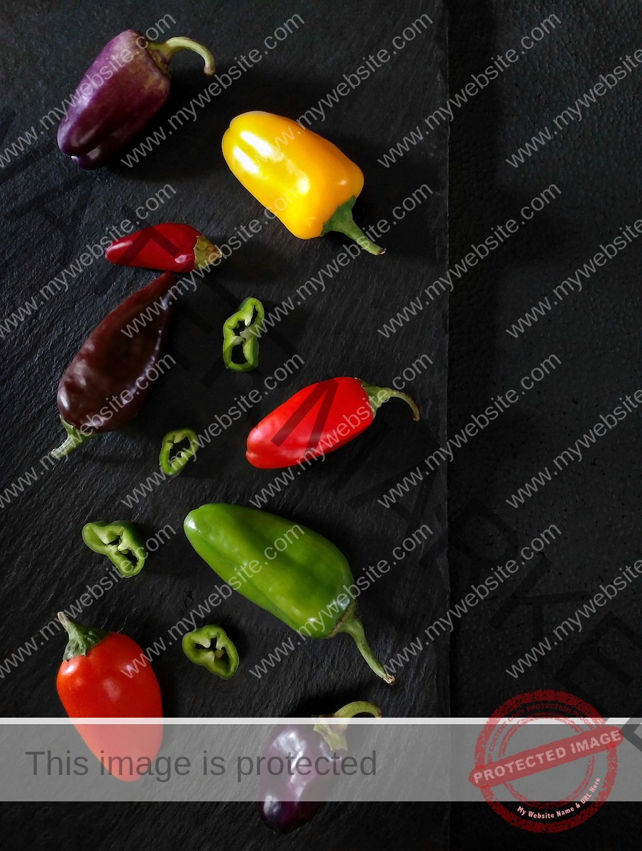 Mix of colorful chili peppers on slate.